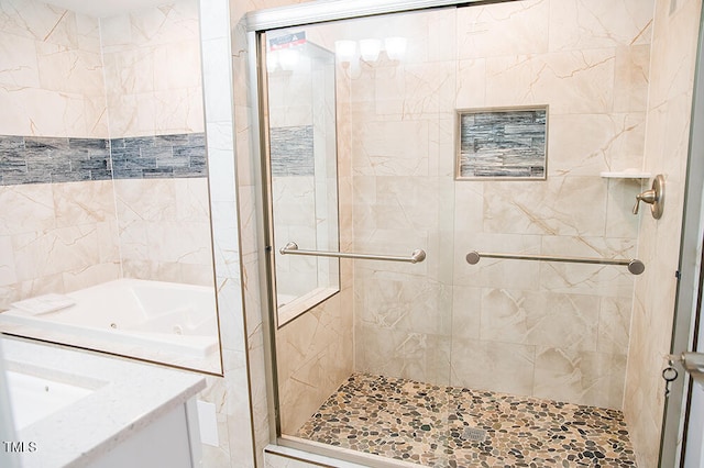 bathroom featuring vanity and independent shower and bath