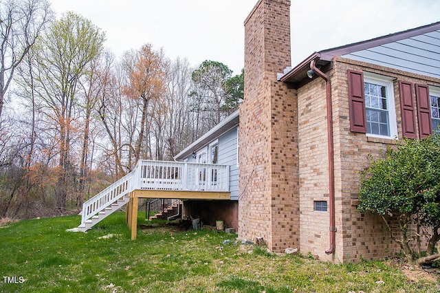 view of side of home with a lawn and a wooden deck