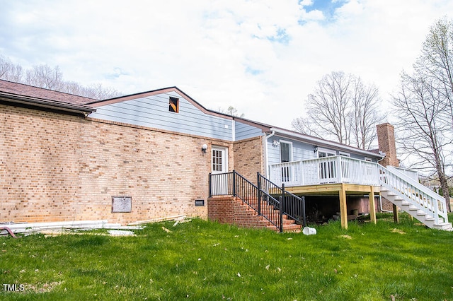 back of property featuring a wooden deck and a lawn