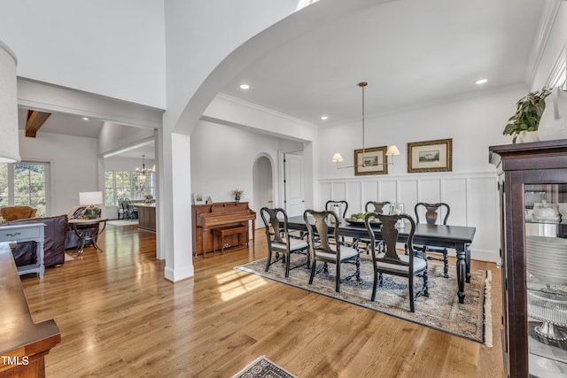 dining room with an inviting chandelier, ornamental molding, and light hardwood / wood-style flooring