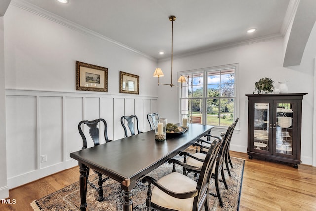 dining area featuring crown molding and light hardwood / wood-style flooring