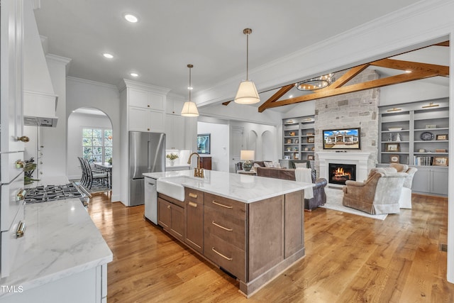 kitchen with white cabinetry, light hardwood / wood-style floors, pendant lighting, and beam ceiling