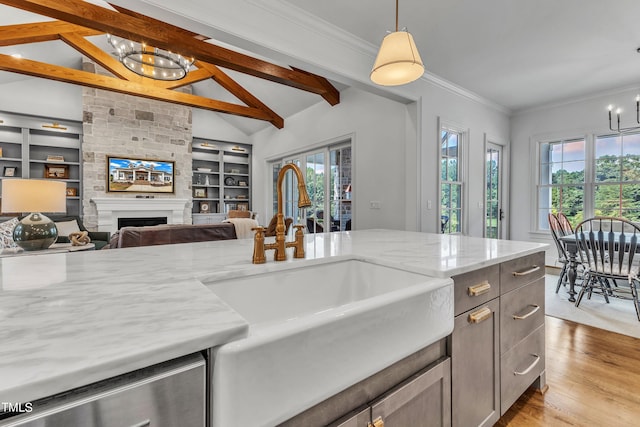 kitchen with decorative light fixtures, light stone counters, light hardwood / wood-style floors, and plenty of natural light