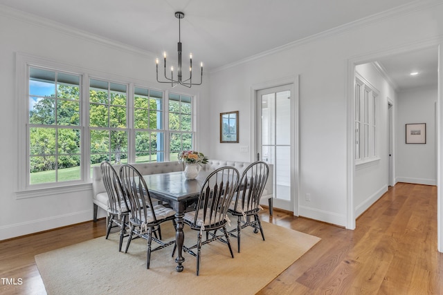 dining area featuring a chandelier, crown molding, a healthy amount of sunlight, and light hardwood / wood-style flooring