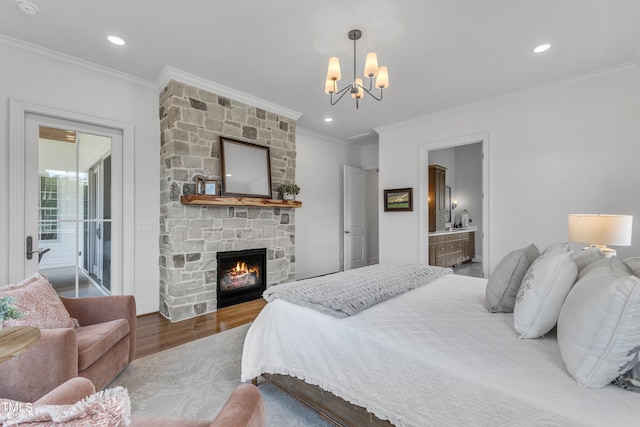 bedroom featuring ornamental molding, access to exterior, a fireplace, wood-type flooring, and a notable chandelier