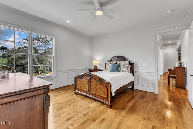 bedroom featuring ornamental molding, light hardwood / wood-style floors, and ceiling fan