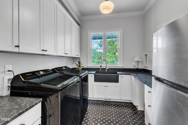 laundry room with washing machine and clothes dryer, cabinets, sink, and ornamental molding