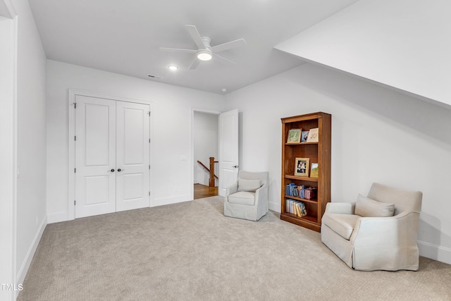 living area featuring ceiling fan and light colored carpet