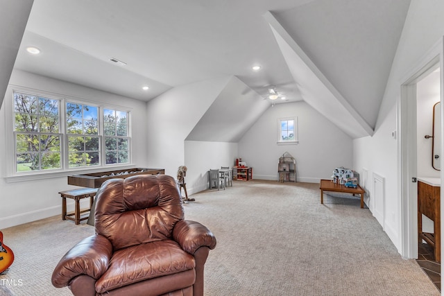 living area featuring ceiling fan, carpet flooring, and vaulted ceiling