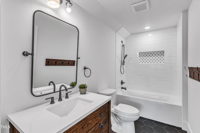 full bathroom featuring tile patterned floors, vanity, tiled shower / bath combo, and toilet