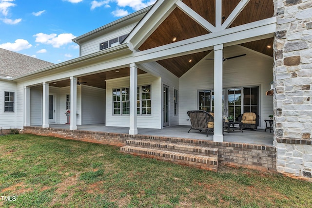 doorway to property featuring ceiling fan, a yard, and a patio area