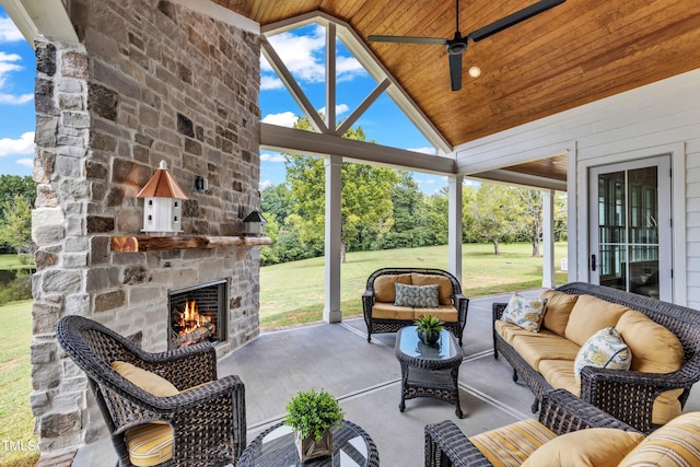 view of patio / terrace with ceiling fan and an outdoor living space with a fireplace