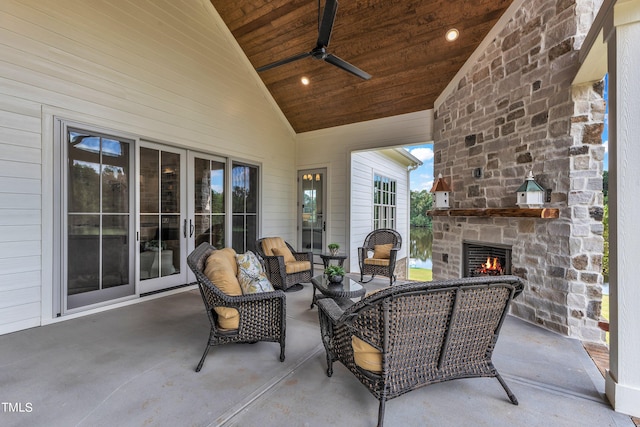 view of patio / terrace featuring ceiling fan and an outdoor stone fireplace