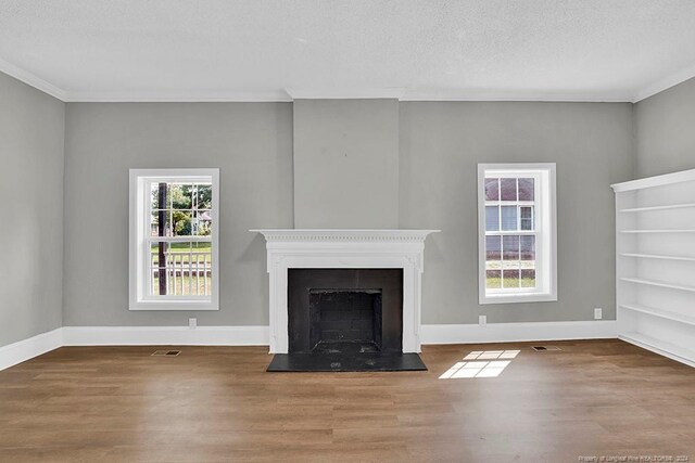 unfurnished living room featuring plenty of natural light and hardwood / wood-style floors