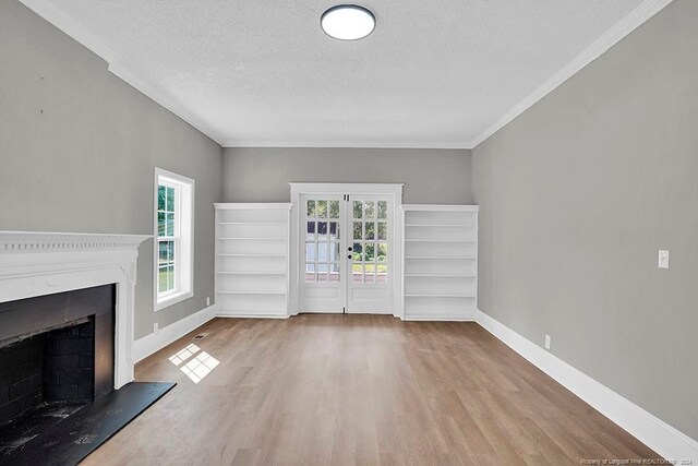 unfurnished living room with a textured ceiling, crown molding, and light hardwood / wood-style floors