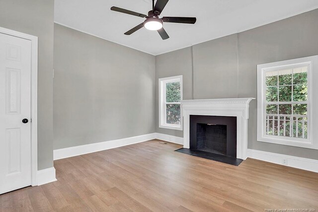 unfurnished living room featuring ceiling fan, plenty of natural light, and light hardwood / wood-style flooring