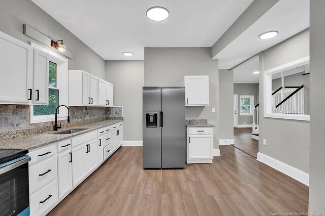 kitchen featuring stainless steel appliances, white cabinetry, and sink