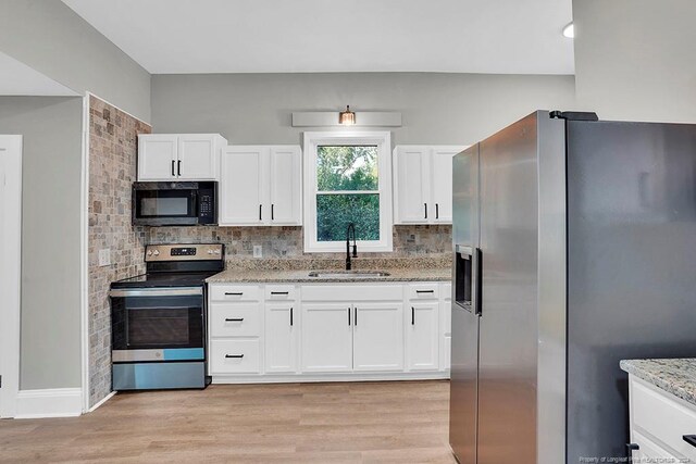 kitchen with white cabinets, appliances with stainless steel finishes, tasteful backsplash, and sink