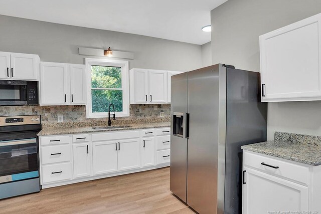 kitchen with stainless steel appliances, sink, decorative backsplash, and white cabinetry