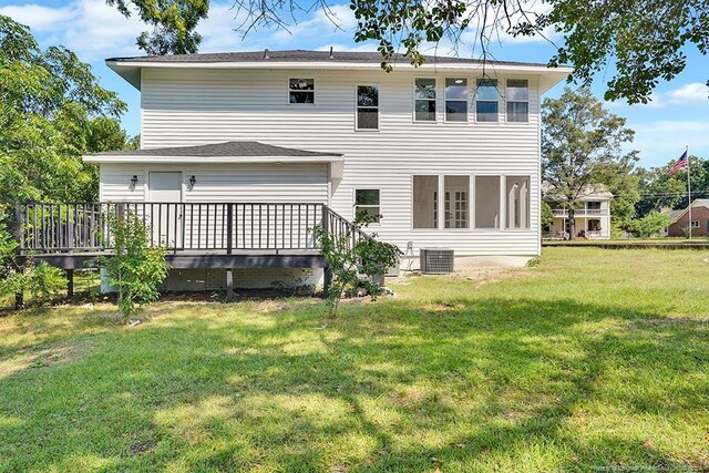 back of property featuring central air condition unit, a lawn, and a wooden deck