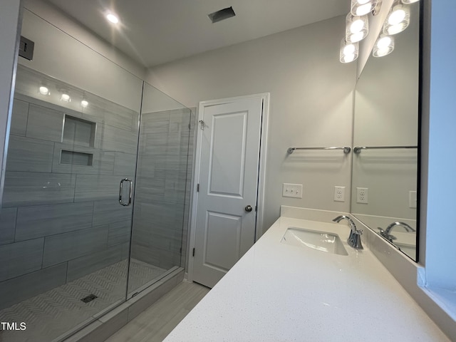 bathroom featuring vanity and an enclosed shower