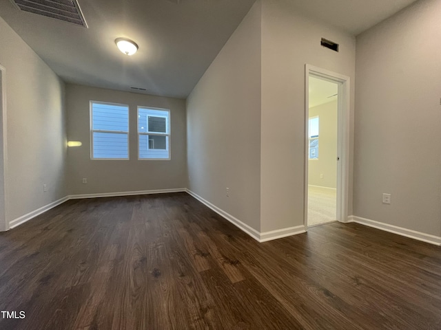 unfurnished room with dark hardwood / wood-style flooring and plenty of natural light