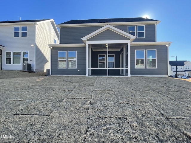 rear view of house featuring central air condition unit and a sunroom