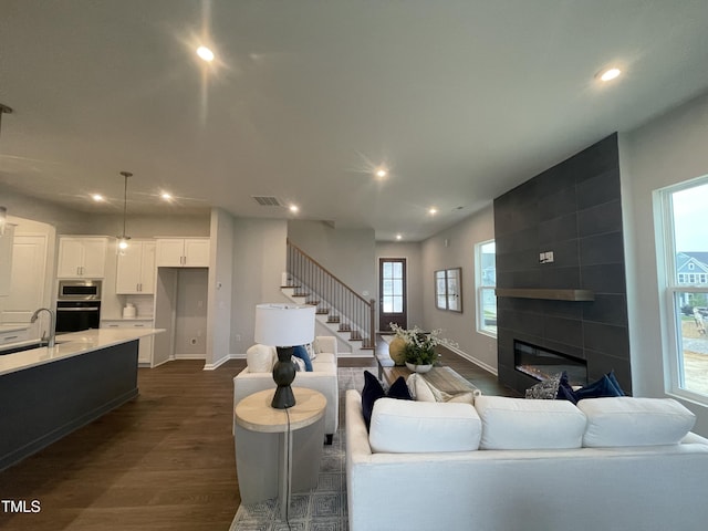 321 Murray Grey Ln, Wake Forest, NC 27587 - living area featuring dark wood finished floors, recessed lighting, healthy amount of natural light, a large fireplace, and baseboards