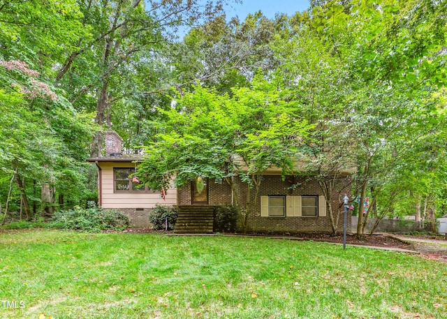 view of property hidden behind natural elements with a front lawn