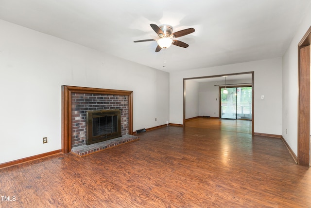 unfurnished living room with dark wood-type flooring, ceiling fan, and a fireplace