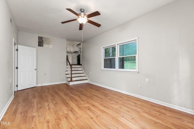 empty room with ceiling fan and light hardwood / wood-style flooring