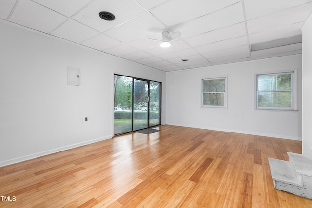 spare room with ceiling fan, a drop ceiling, and light hardwood / wood-style flooring