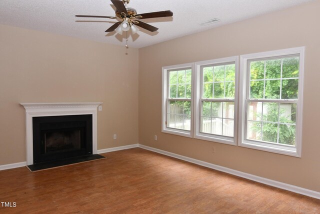 unfurnished living room with light wood-type flooring, a textured ceiling, and ceiling fan