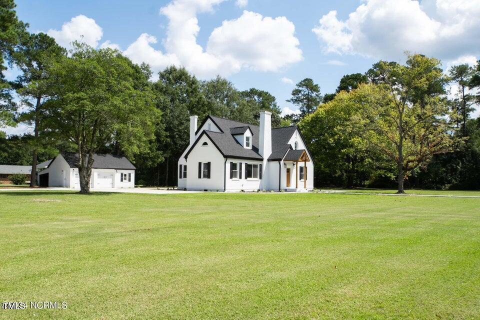 608 N E St, Roseboro, NC 28382 - view of front of property with a chimney, a front yard, and an outdoor structure