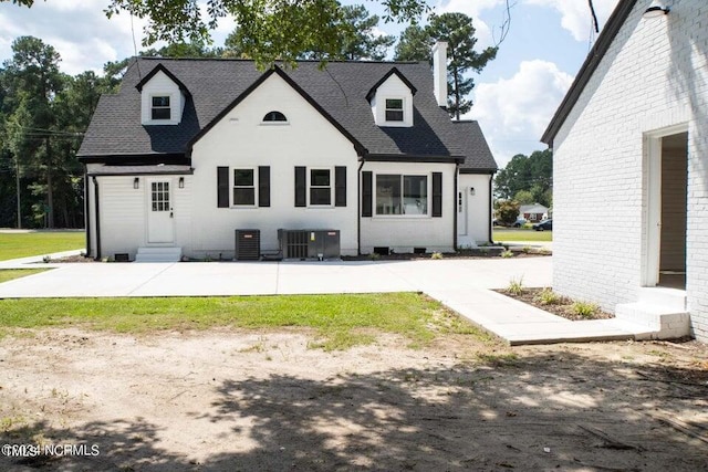 view of front of house with entry steps, a patio, cooling unit, and a shingled roof