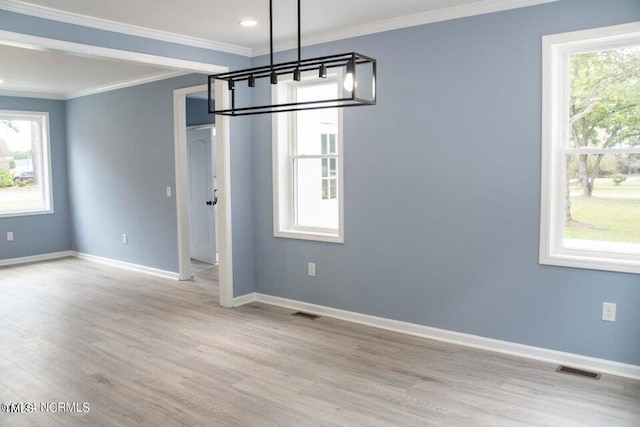 unfurnished dining area with visible vents, wood finished floors, baseboards, and ornamental molding