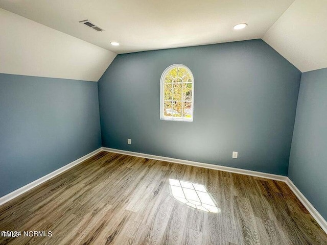 bonus room with visible vents, baseboards, wood finished floors, and vaulted ceiling