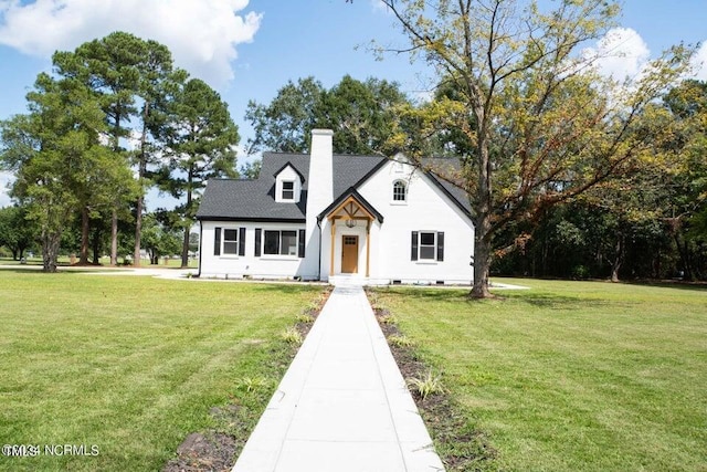 view of front of house featuring a chimney and a front lawn