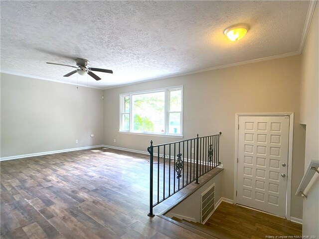 interior space with ceiling fan, dark hardwood / wood-style flooring, crown molding, and a textured ceiling