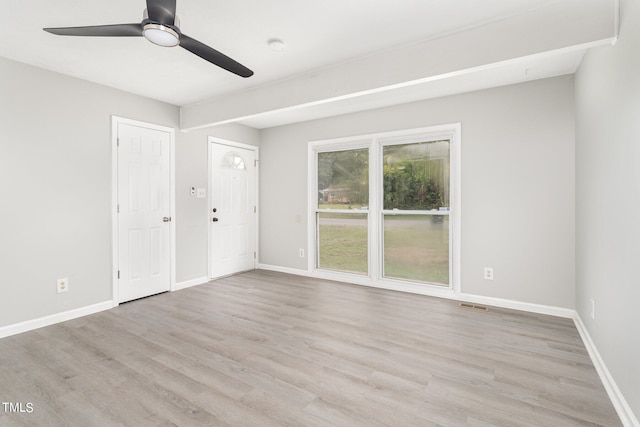 empty room featuring visible vents, ceiling fan, light wood-type flooring, and baseboards