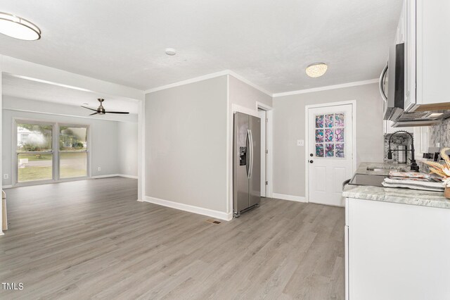 kitchen featuring crown molding, light hardwood / wood-style flooring, ceiling fan, appliances with stainless steel finishes, and white cabinets