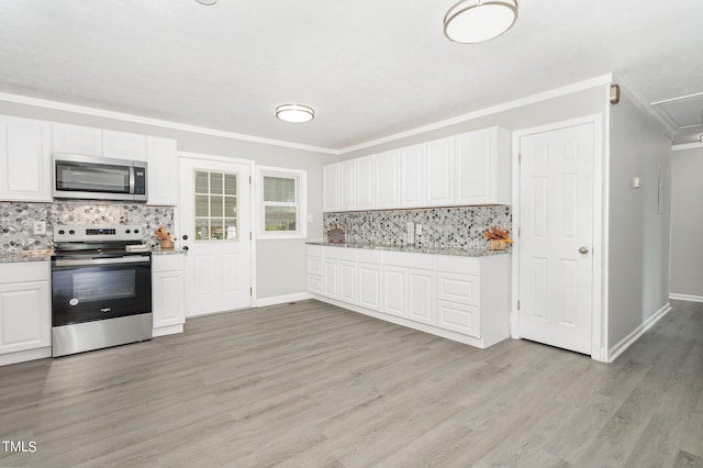 kitchen with white cabinetry, stainless steel appliances, light hardwood / wood-style floors, backsplash, and ornamental molding