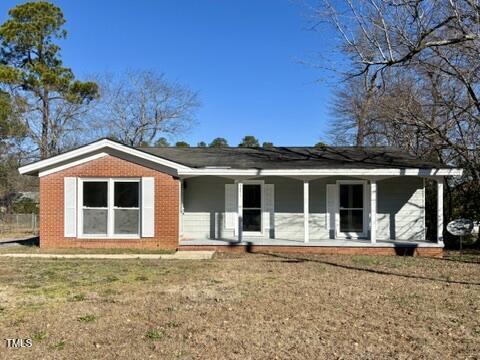 single story home featuring a front yard and covered porch