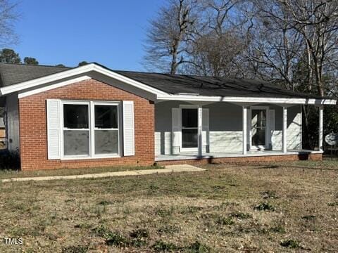 back of property with a lawn and brick siding