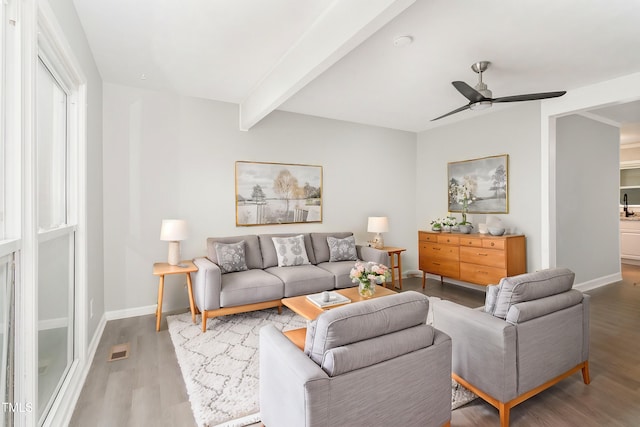 living room with ceiling fan, sink, wood-type flooring, and beam ceiling