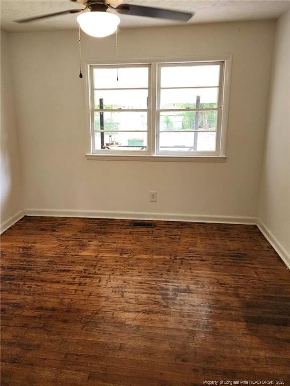 unfurnished room with ceiling fan, dark hardwood / wood-style flooring, and a textured ceiling