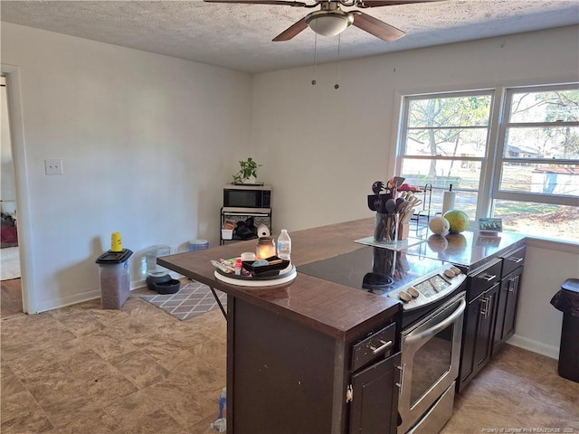 kitchen with ceiling fan, dark brown cabinets, stainless steel appliances, and a textured ceiling