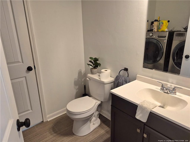 bathroom featuring separate washer and dryer, vanity, and toilet