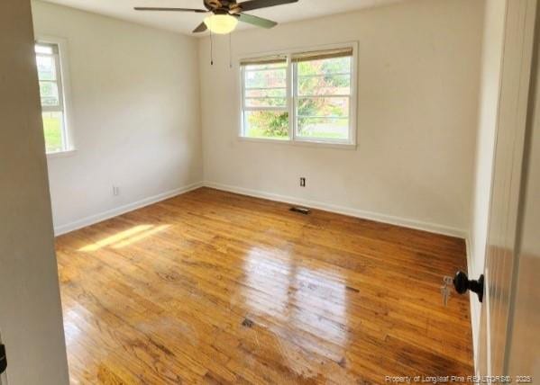 spare room with wood-type flooring and ceiling fan