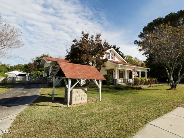 view of front of home featuring a gazebo, a front lawn, and covered porch